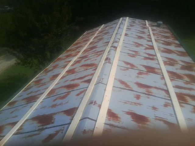 Rusted metal roof panels with new wood purlins before replacement — Storm Damage Roof Repair in Wesson by Roofing Brothers