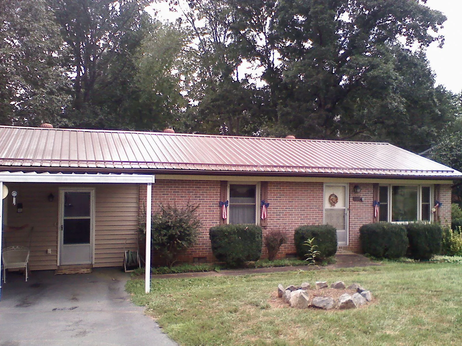Bronze metal roof and carport on a brick ranch home — Roof Repair work by our crew in Wesson